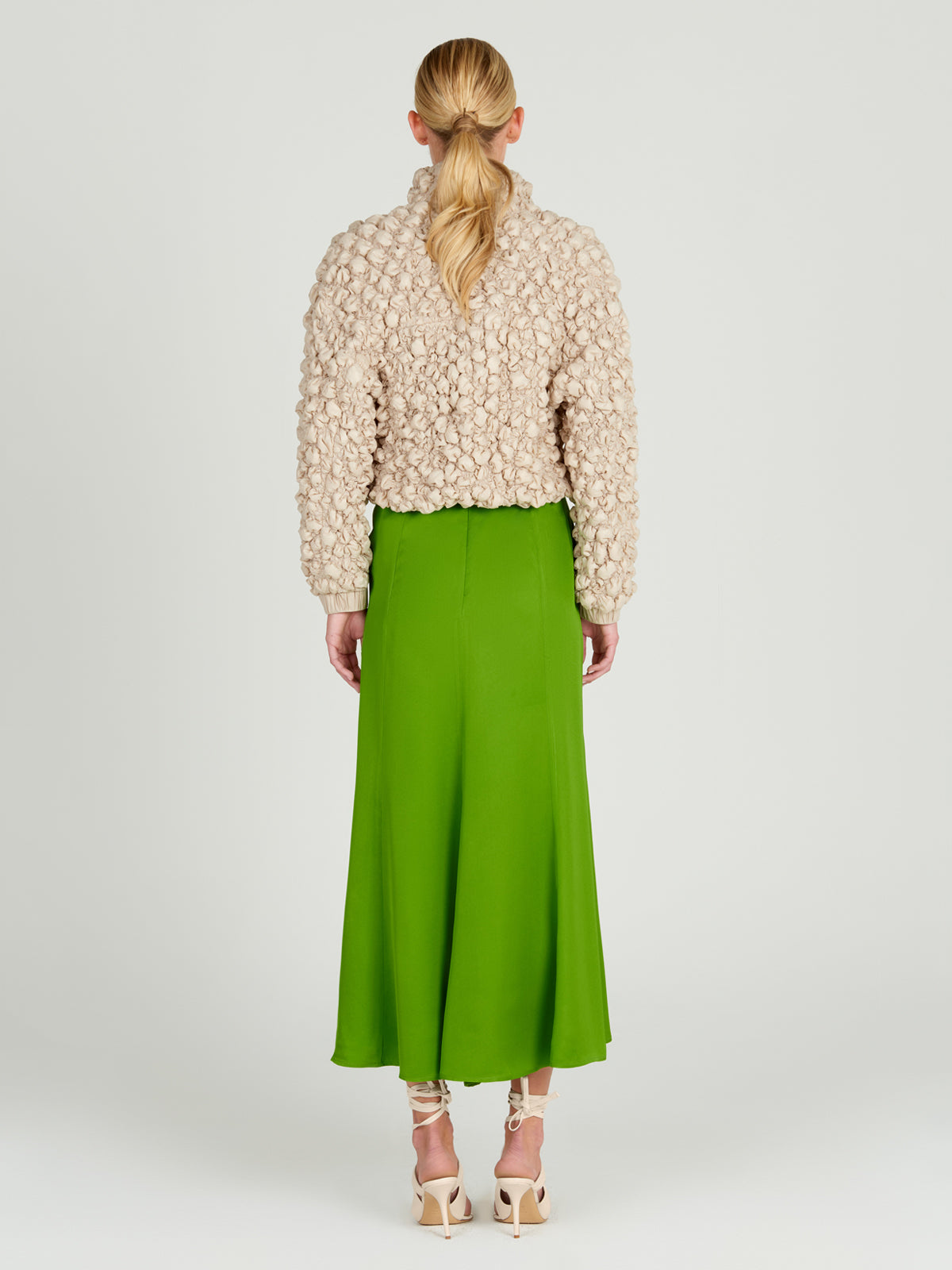 A women's Zalta Jacket Beige with ruffled details.