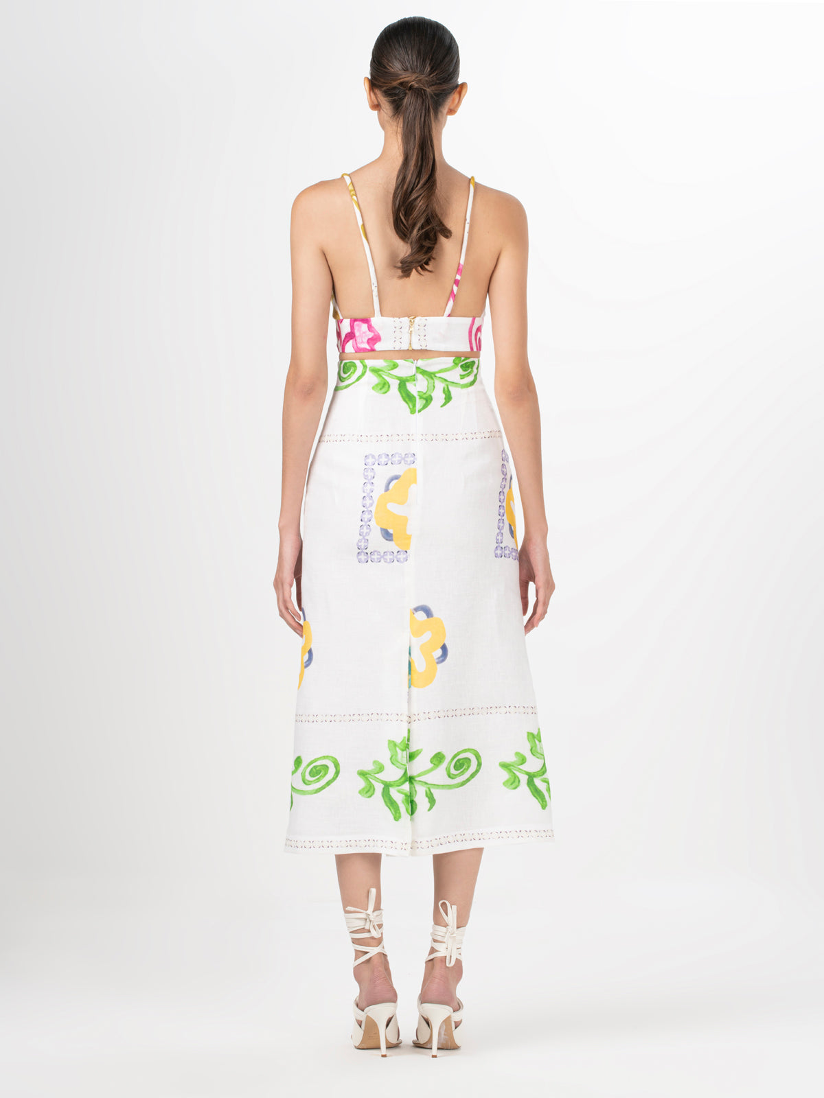 A Flor Top Multicolor Floral Print bikini top with a bow and gold accents.