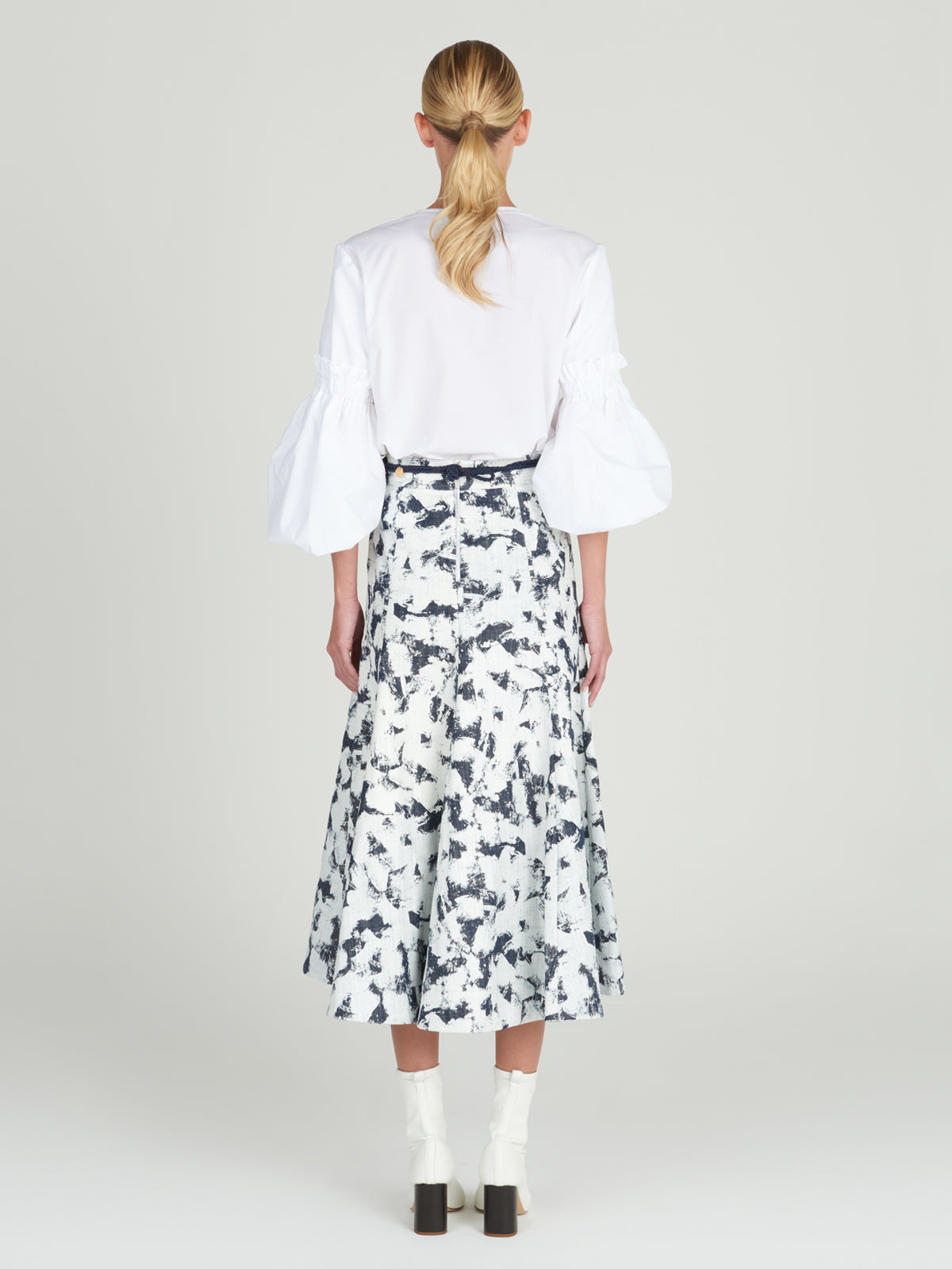 A Wenda blouse white with floral applique on the sleeves.