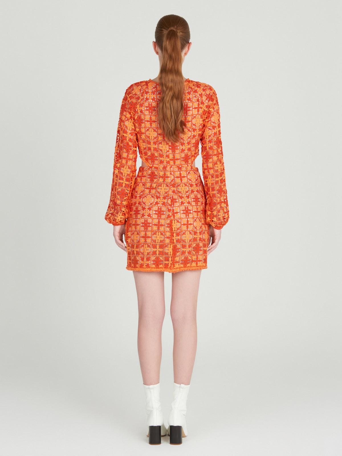 A figure-flattering Janis Dress Red Orange Crochet displayed on a mannequin.