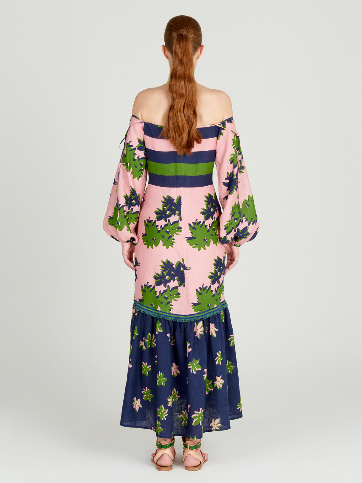 Oristano Dress Navy Pink with off-the-shoulder style and blue and green flowers on it.