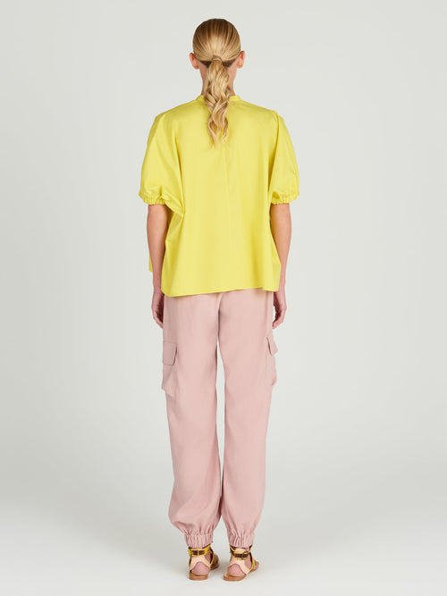A Susanne Blouse Limoncello with a pink floral design.